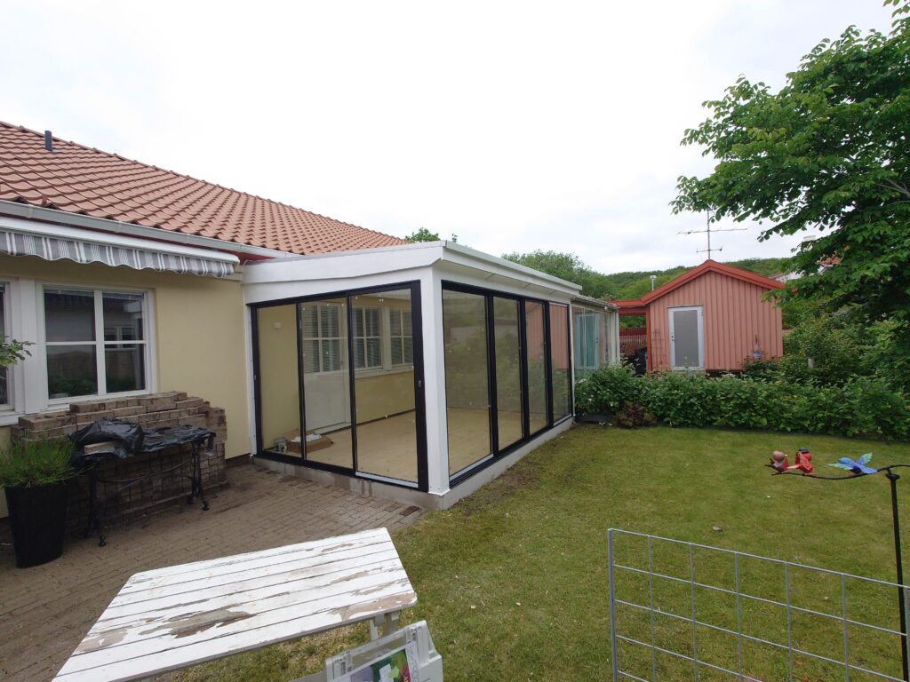 Inglasat uterum intill en villa med tegeltak
