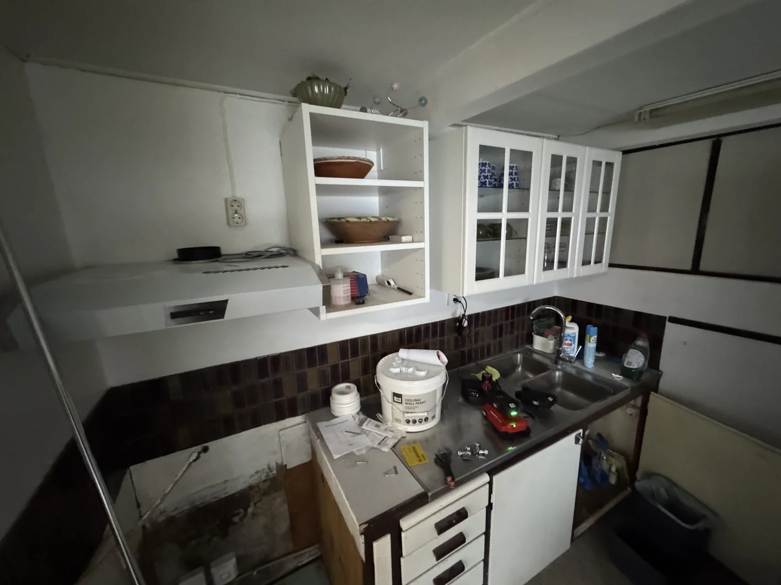 Äldre kök under renovering med befintliga överskåp och frilagd arbetsyta