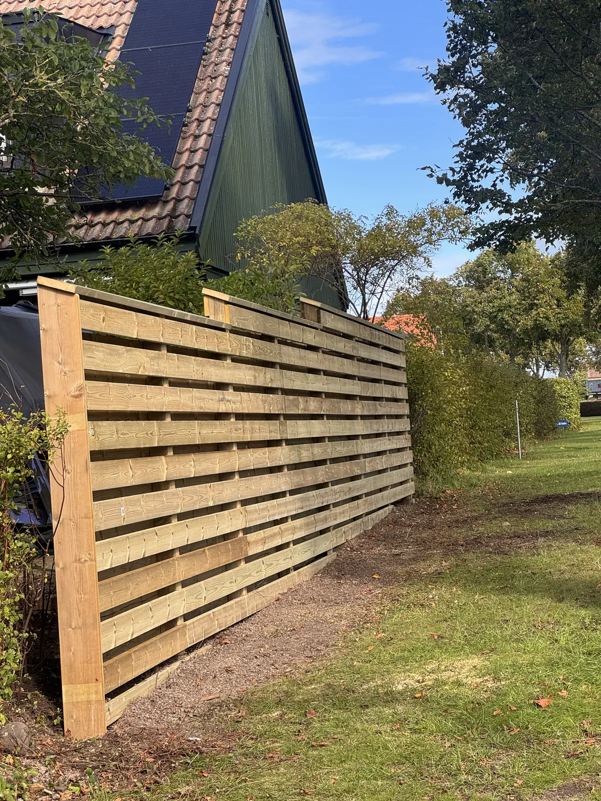 Träplank med liggande brädor vid en trädgård i Lerberget