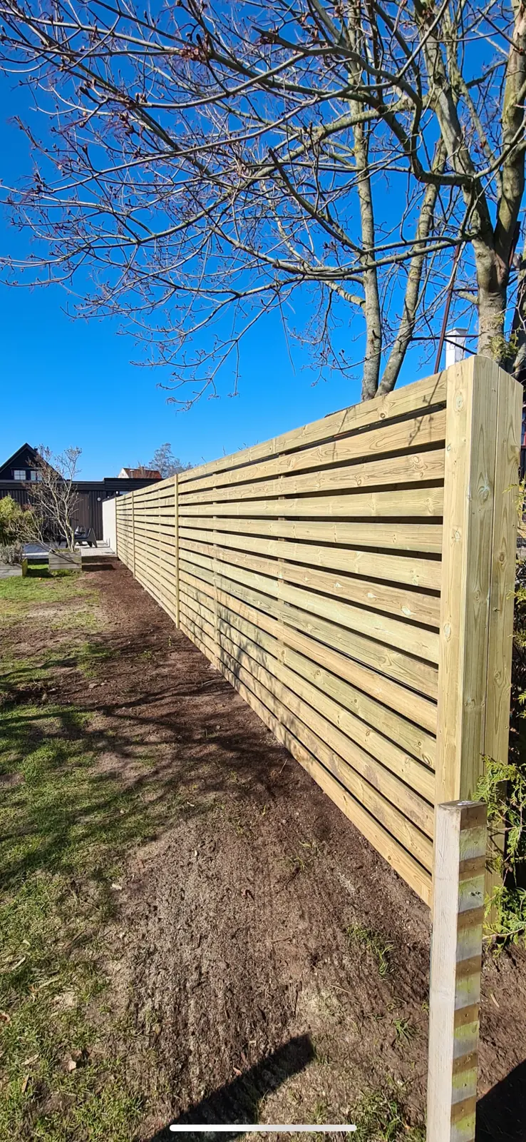 Träplank med liggande brädor och breda stolpar i Vejbystrand